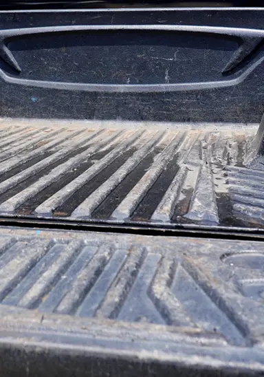 Dents and impact marks on truck bed from heavy loads dropped during loading